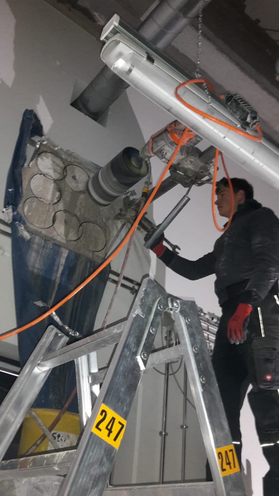 Kernbohrung in Betondecke, Arbeit auf Leiter